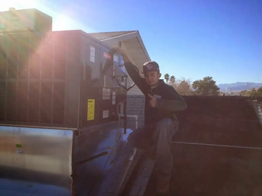 HVAC technician performing HVAC Inspection on a rooftop unit in Lenoir City